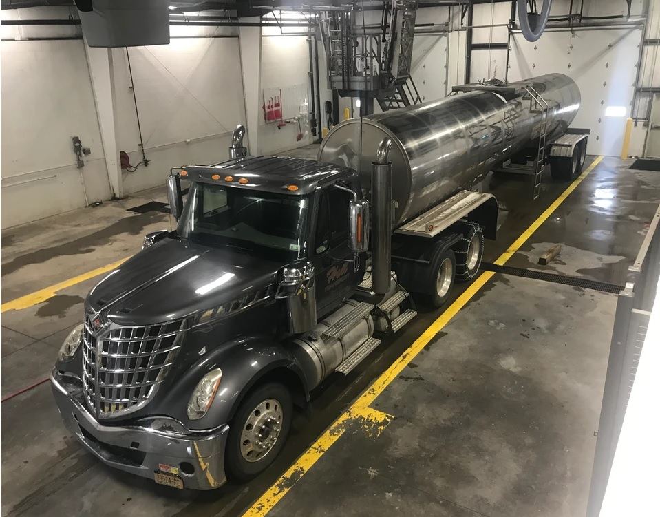 Interior tank wash bay for tanker trailers